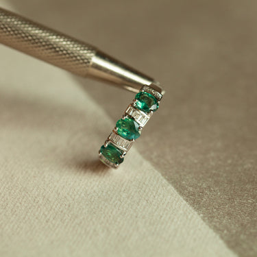 18k white gold ring with three oval green alexandrite stones and sparkling baguette diamonds on band